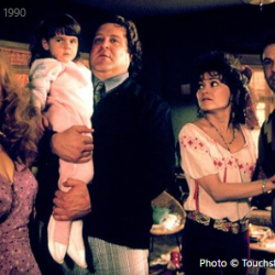 Group of five adults and a baby in a living room; still from the 1990 film Stella.