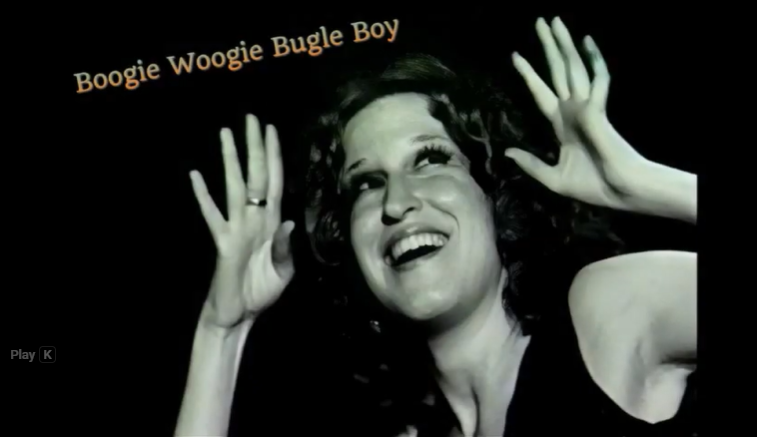 Smiling woman with dark hair, hands raised in a joyful pose, 'Boogie Woogie Bugle Boy' title above the scene (retro performance vibe). - Informative image suggesting a musical performance captioned thumbnail.