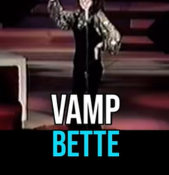 Stage performance by VAMPETTE: a woman in a metallic jacket raises her arm on a dark stage, with 'VAMP BETTE' text shown at the bottom.