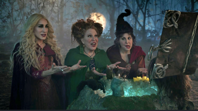 2026-07-17_15-19-51 - bootleg betty Three witches in colorful costumes chant over a glowing ice-filled cauldron in a moonlit forest.