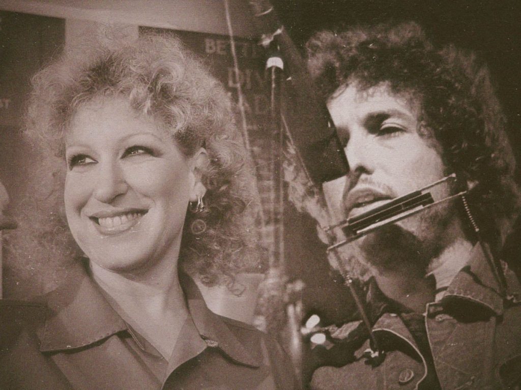 Be-a-fly-on-the-wall-when-bob-dylan-and-bette-midler-went-into-the-studio-together-1975-dangerous-minds - bootleg betty Smiling woman with curly hair beside a man wearing a large headset mic in a vintage photo.