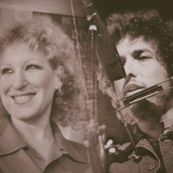 Smiling woman with curly hair beside a man wearing a large headset mic in a vintage photo.