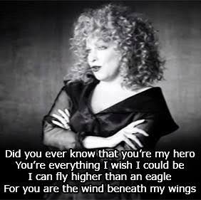 Black-and-white photo of a curly-haired woman with arms crossed; overlaid with Wind Beneath My Wings lyrics.