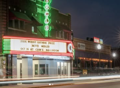 Night view of Cain's Ballroom with a glowing marquee advertising the 2026 Woody Guthrie Prize — Bettie Miller, Oct 16 at Cain's Ballroom on a neon-lit street night scene.