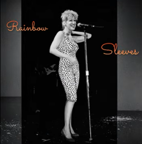 Singer on stage with a microphone wearing a leopard-print top; orange cursive text 'Rainbow' on the left and 'Sleeves' on the right.