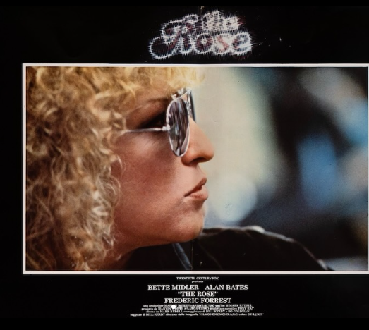 Album cover showing a profile of a woman with curly blonde hair and sunglasses; dark background, bordered photo, 'The Rose' title above and credits below (no names shown).