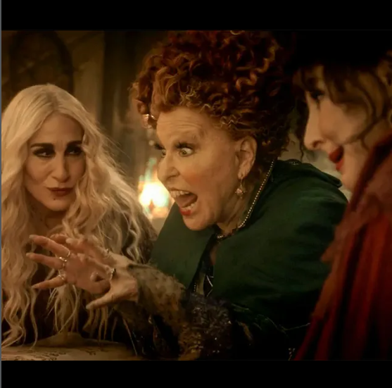2026-09-05_10-32-56 - bootleg betty Three witches lean in around a table in a dim tavern, with the red-haired one shouting and gesturing dramatically at the others.