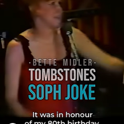 2026-09-25_19-48-31 - bootleg betty Stage performer on a dark set with on-screen text: 'BETTE MIDLER', 'TOMBSTONES', 'SOPH JOKE'; caption reads 'It was in honour of my 80th birthday'.