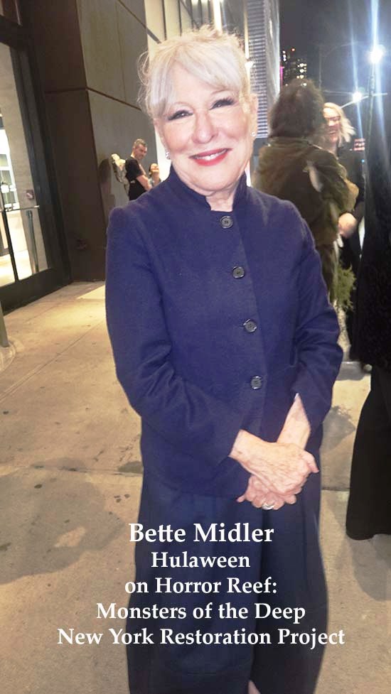 Smiling woman in a dark blue coat posing on a city sidewalk at night; overlaid text references Hulaween and Monsters of the Deep for the New York Restoration Project.